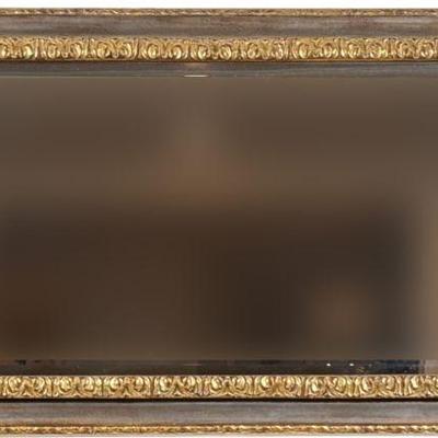 A FANCY CARVED GILT BEVELED LONG MIRROR | 19th/20th century; having a central aged mirror within a border of carved gilt wood, surrounded...
