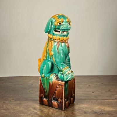 CHINESE FOO DOG CERAMIC FIGURE | Marked Hong Kong and with numbers. Green painted ceramic dog sitting on top of a brown pedestal. - h. 19...