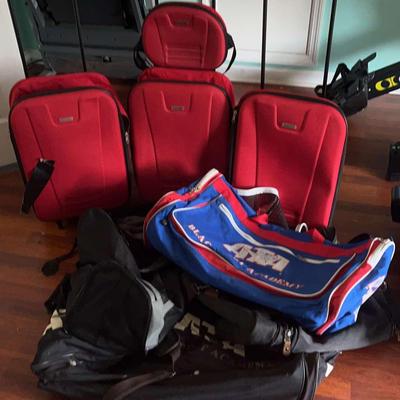 Three Carry-On Suitcases And Several Backpacks With Duffel Bags