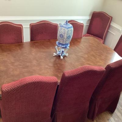 Dining room table and 8 chairs with red cover and 2 leaves
