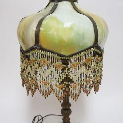 1006	ANTIQUE ART NOUVEAU PANELED CURVED SLAG GLASS TABLE LAMP HAVING BEADED TASSLES, APPROXIMATELY 28 IN HIGH
