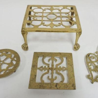1069	GROUP OF ANTIQUE BRASS TRIVETS, LARGEST APPROXIMATELY 9 IN X 8 IN X 5 IN H
