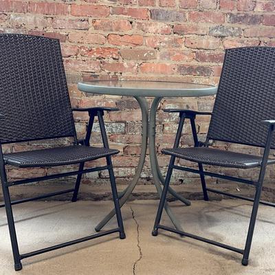 Outdoor Glass Top Table With A Pair Of Vinyl Folding Chairs 