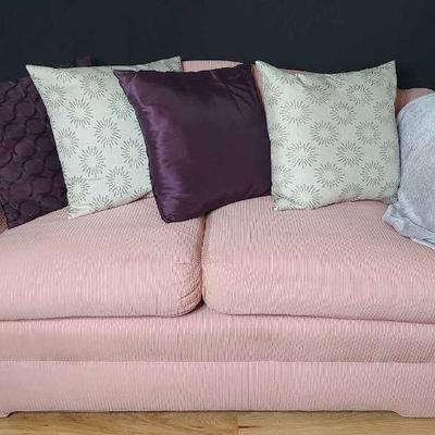 Pink loveseat with pillows