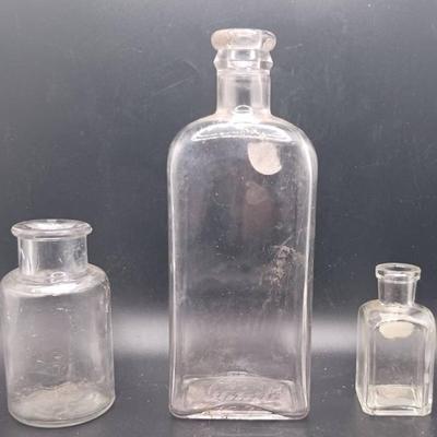 (3) Glass Bottles Glowing Green in Ultraviolet Light