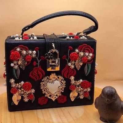 Black Box Handbag with Red Floral Embellishments and Lock Closure