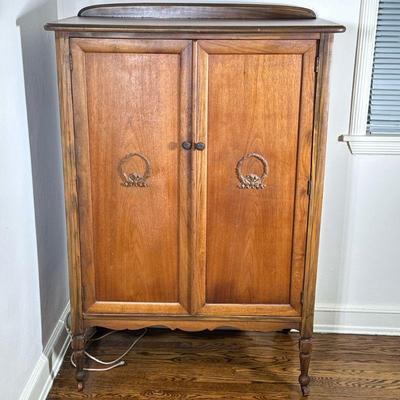 Small Armoire with Carved Details | Vintage armoire on caster wheels, with detailed carvings on the front doors, four pull...