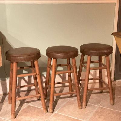 (3pc) Oak Wooden Counter-Height Stools | Set of three (3) oak wooded four-legged counter-height stools with rounded, tan pleather or...