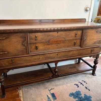 Jacobean style wood side board with ornate strap hinges