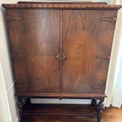 Jacobean style wood cabinet with ornate strap hinges