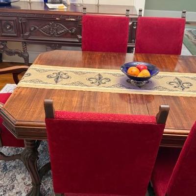  Mahogany dining room table with scroll legs  
- Set of 6 matching chairs, including 1 captain's chair with red upholstery  