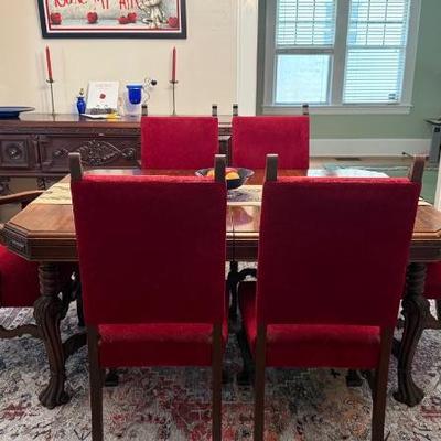  Mahogany dining room table with scroll legs  
- Set of 6 matching chairs, including 1 captain's chair with red upholstery  