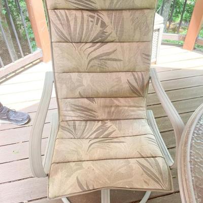 Outdoor glass top with metal base dining table, with 4 swivel/rocking chairs 