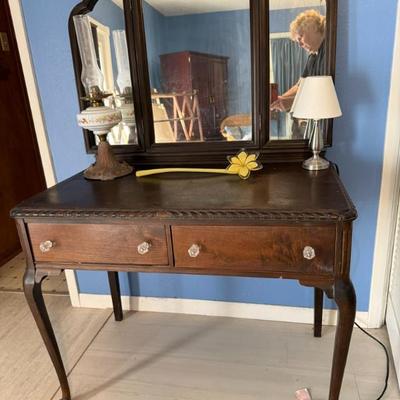 Antique dressing table with mirror. Antique oil lamp. Desk lamp