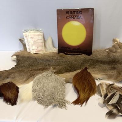 Animal  hide, with some feathers and a book.