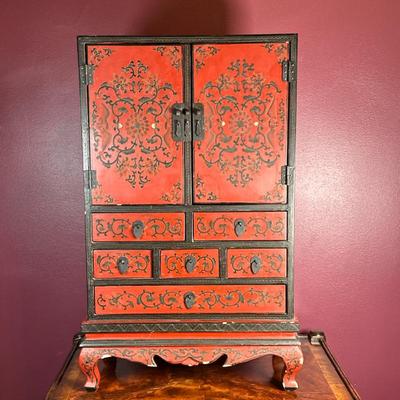 Chinese Red Lacquered Jewelry Cabinet | Vintage (20th c.) red lacquered jewelry cabinet with hinged doors on cabinet and several drawers...