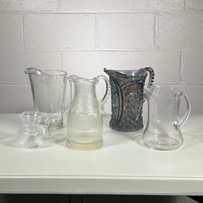 (5pc) Glass Pitchers | Including two blown glass pitchers, one non-descript, one etched glass, and a vintage carnival smoky cut glass...