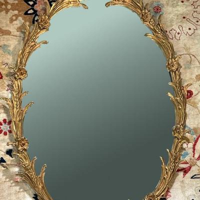 Gold Gilt Framed Mirror | Ovular French Provincial gilded gold mirror with floral and acanthus leaves carvings. Wire hanging on verso. -...