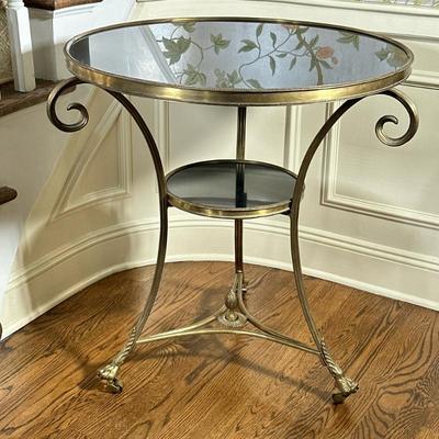 Gueridon Side TABLE | Having black stone top and matching lower tier; brass round table with claw feet. Curved gilt metal frame....