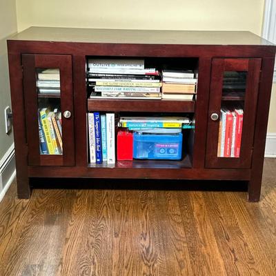 WOOD BOOKSHELF | Having 2 small glass doors flanking center open cabinet with 2 shelves Dimensions: h. 27.25 x w. 42 x d. 20 in