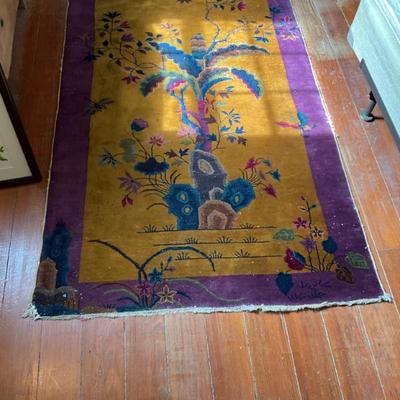 Art deco rug made in China, purple boarder gold center with tree and flowers measures. 48” x 79” pretty good condition