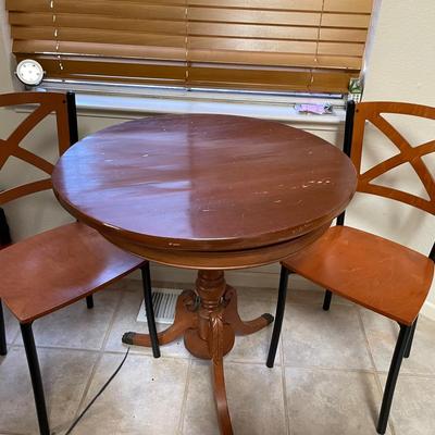 Round Wood Pedestal Table with Two Wooden Cross-Back Chairs