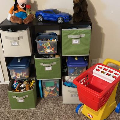 Storage Unit With Assortment Of Kids Toys, kids shopping cart, Disney toys