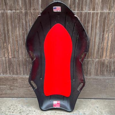 Black Plastic & Styrofoam Sled | Black plastic sled with handles and rope for pulling. Red styrofoam lining. - h. 6.5 x w. 26 x l. 47...