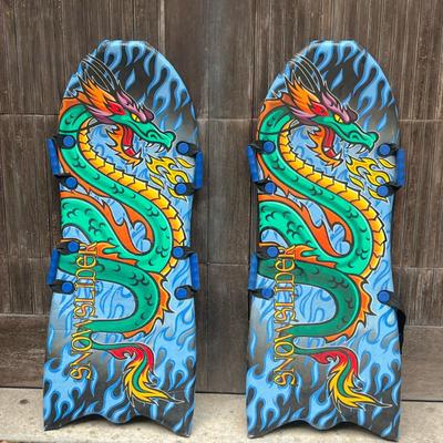 (2pc) Pair Snowboards | Pair of Snowsliders with Dragons and four handles. One handle is broken. Dimensions: w. 21 x l. 52 in
