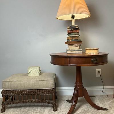 Round Side Table, Wicker Ottoman, and Book Stack Lamp