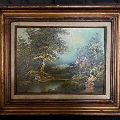 Lot 302: Framed Oil Painting – Rustic Cabin Landscape Signed “Austin”