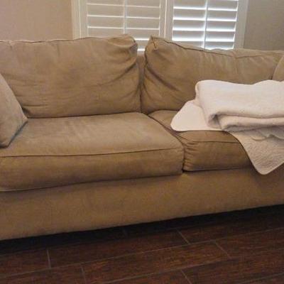 Beige Suede Sofa 84"×37"×31" W/ 2 Throw Pillows And White Blanket