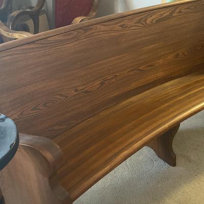 An Old Curved Church Pew And An Old Pillar Type Stand