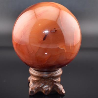 1.985.7 Carat Carnelian Orb on Wooden Stand