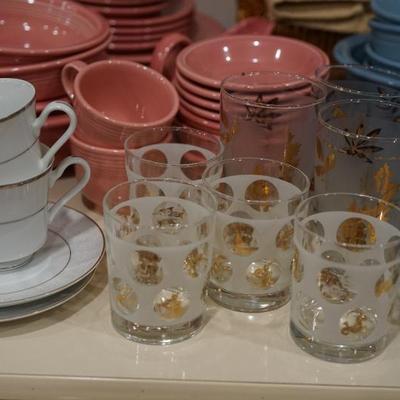 Salmon colored Fiesta ware mis match of plates, bowls and more. 