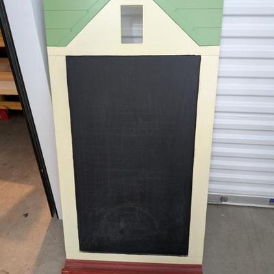 A unique and substantial chalkboard, crafted from durable wood and designed in the shape of a charming house with a green roof and red...