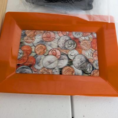  A sturdy orange plastic tray featuring a realistic printed coin design on the bottom. Perfect for teaching money recognition, counting...