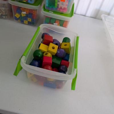 A large and vibrant collection of high-quality wooden beads in various shapes (cubes, spheres, cylinders) and colors, all with holes for...