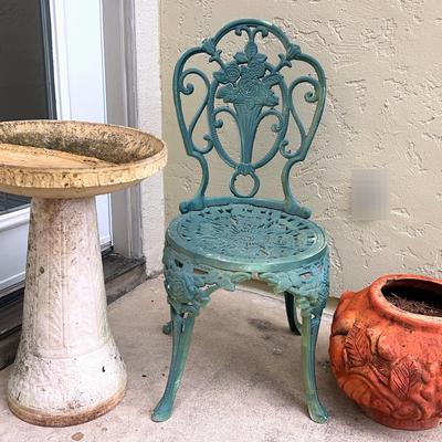 Patio Decor: sculpted terracotta pot, iron Rose Chair, and light terracotta birdbath