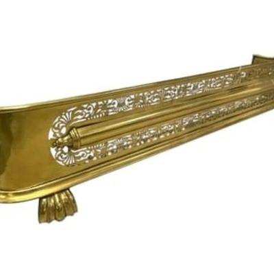 Antique Footed Brass Fireplace Fender with pierced fretwork and armament decoration with a base of claw feet. Measures 47" x...
