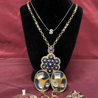 Rhinestone Necklace, Silver Necklace, Gem Earrings, Silver Pendant, Gold Earrings, And A Brooch