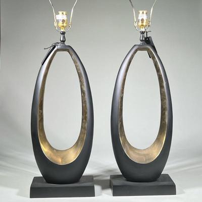 Pair Modern Black Oval Tall Table Lamps | Tall sculptural table lamps, each with an open oval form in black and gold tone finish, mounted...