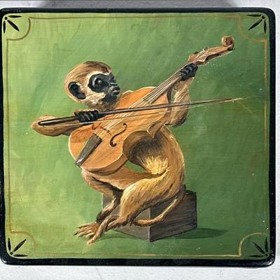 Hand-Painted Lacquered Box With Monkey | A lacquer lidded box of square form, hand-painted with a whimsical scene of a monkey playing a...