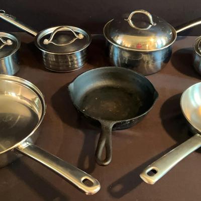 Collection Of Stainless Steel Pots And Pans And A Cast Iron Skillet