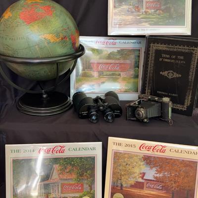 Decorative Globe And Vintage Camera Featuring Signed Jim Harrison Coca Cola Calendars 