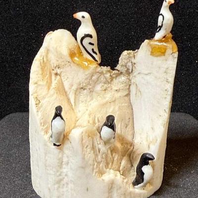 Mike saclamona carving alaskan birds on a rock"
