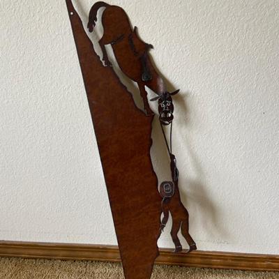 Metal Wall Hanging Of Horse Holding Cowboy Over A Cliff