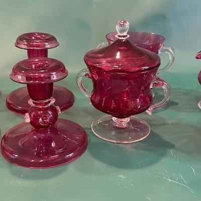 Cranberry glass creamers sugar and candle stick holders