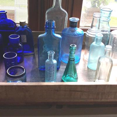 Collection Of Vintage Blue And Clear Bottles On Wooden Tray
