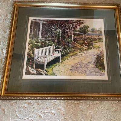 The image displays a framed art print or painting, likely a watercolor, depicting a tranquil garden 